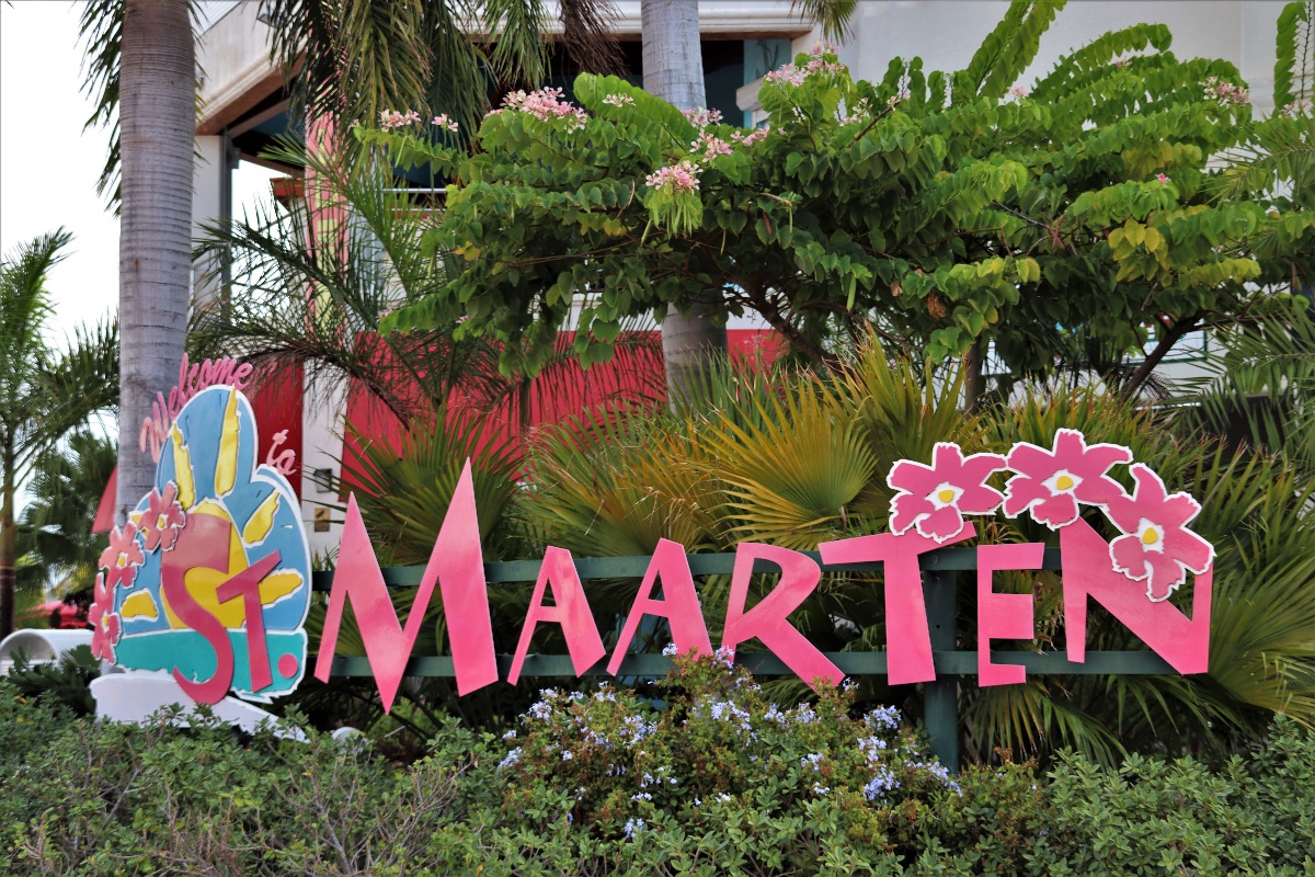 Opschrift "St. Maarten" in roze letters, met bloemen en een zonsopgang erbij getekend.