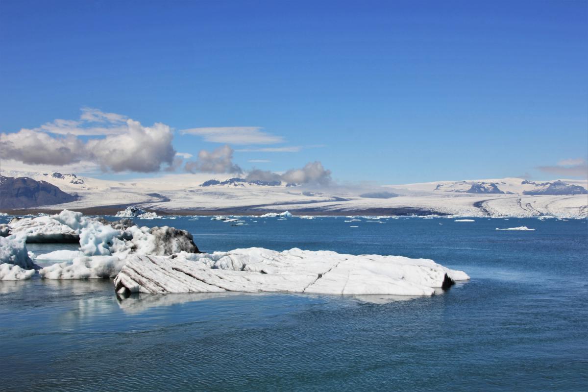 Helblauw gletsjermeer met ijsschotsen.