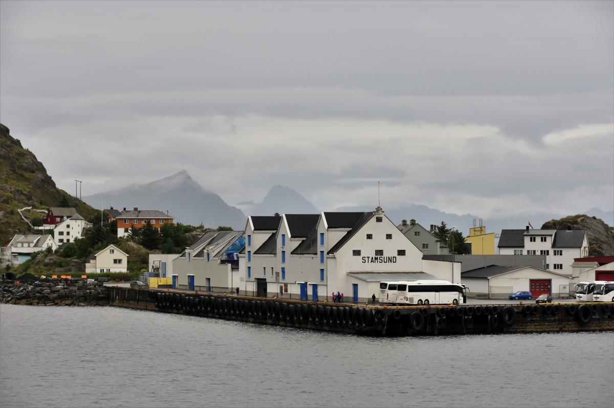 Witte havengebouwen verwelkomen de bezoeker in Stamsund.