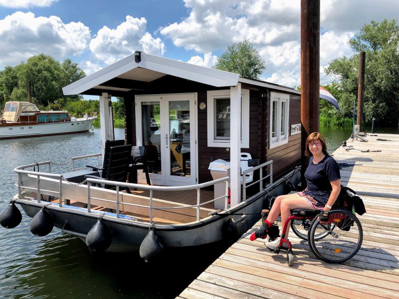 Vanja poseert met haar rolstoel naast de boot.