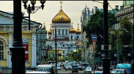 Een drukke straat in Moskou, met de kathedraal dominant in beeld.