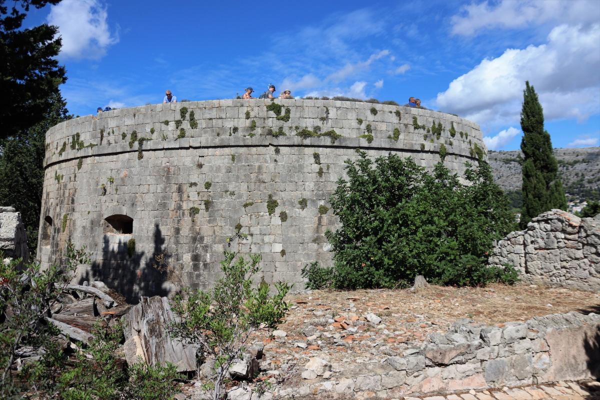 Toeristen op het dak van het ronde, solide gebouwde fort.