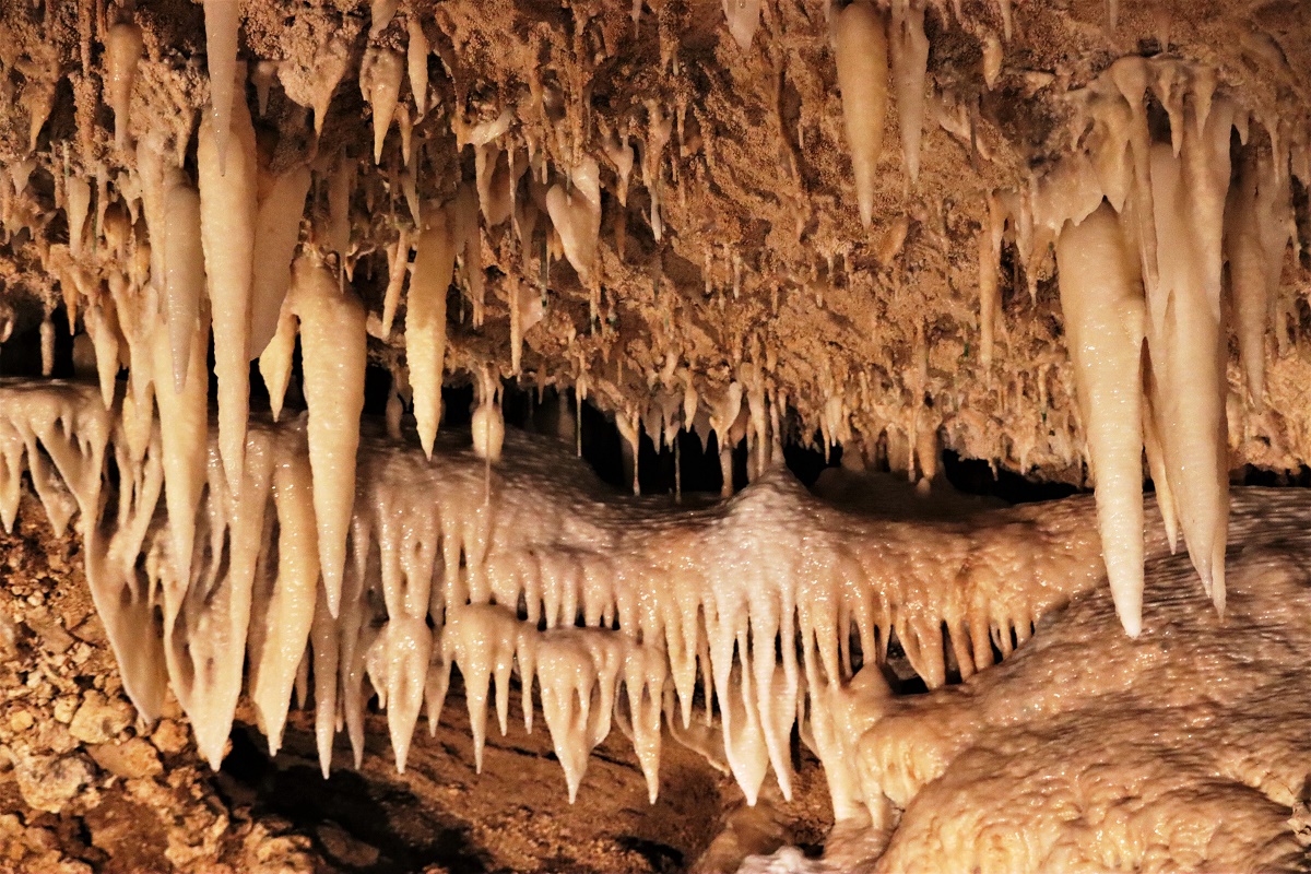 Rijen stalactieten hangen als een vervaarlijke tandenrij aan het plafond van de grot.