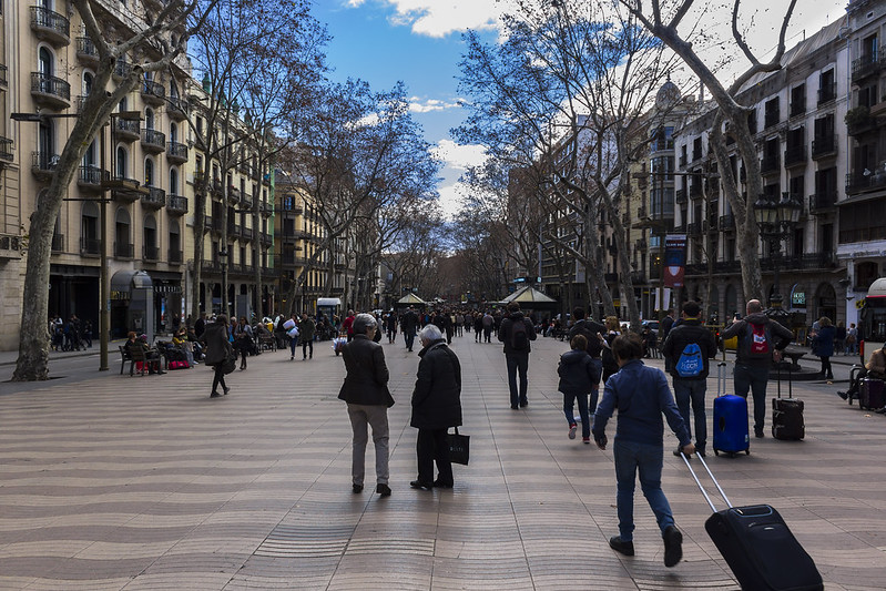 Toeristen wandelen over de Ramblas.