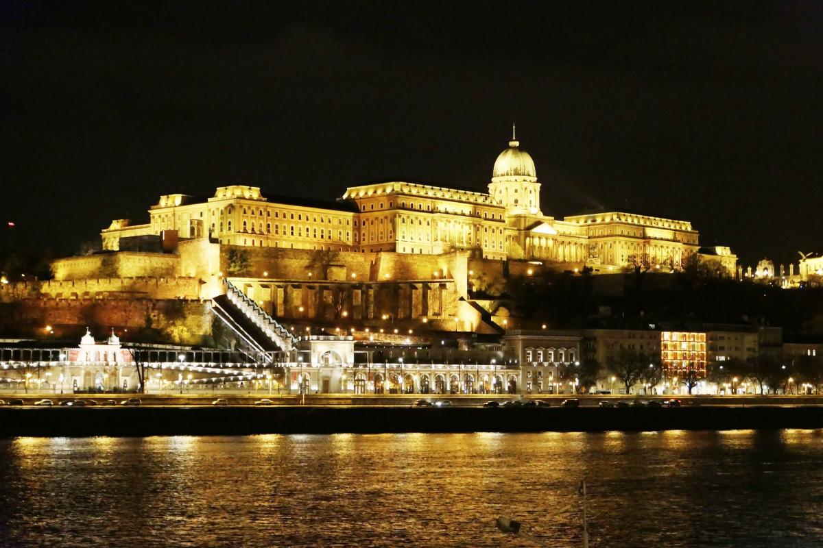 Fraai verlichte historische gebouwen, gefotografeerd vanop een boot op de Donau.