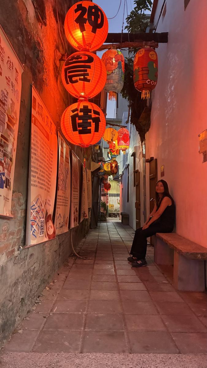 Rusten op een bankje in een steegje, verlicht met rode lampions.