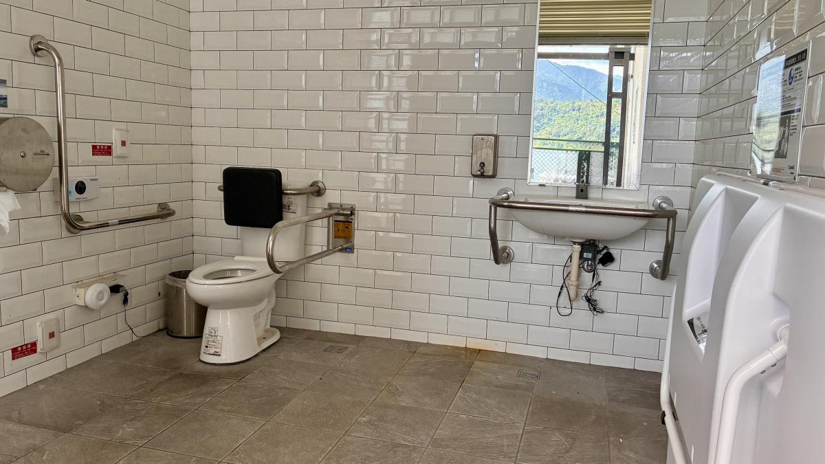 Publieke toiletruimte met verzorgingtafel voor volwassenen.