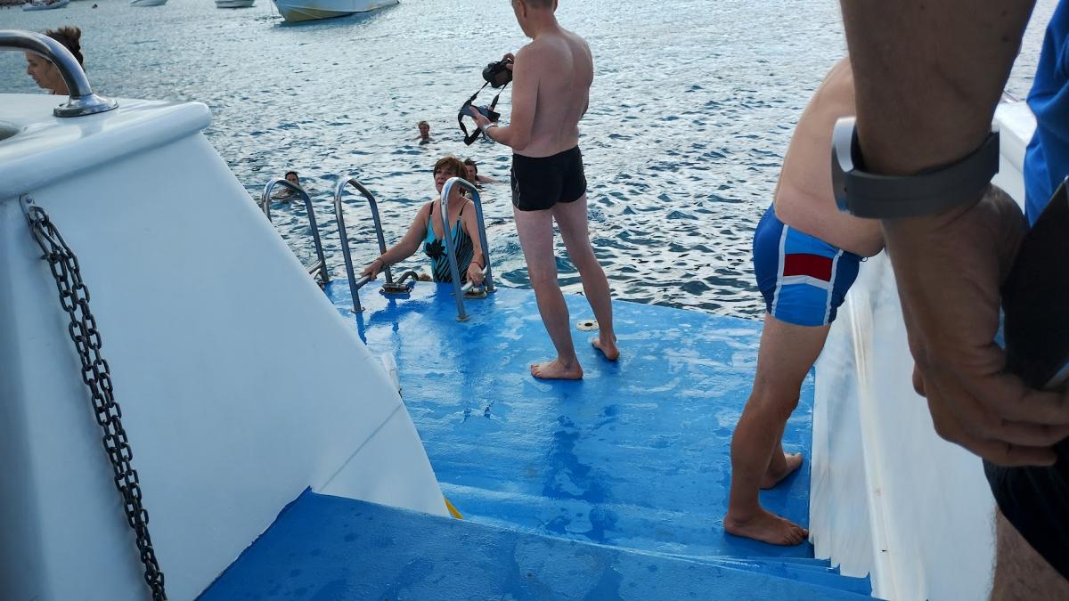 Vanaf het achterdek dalen waterliefhebbers af in zee.