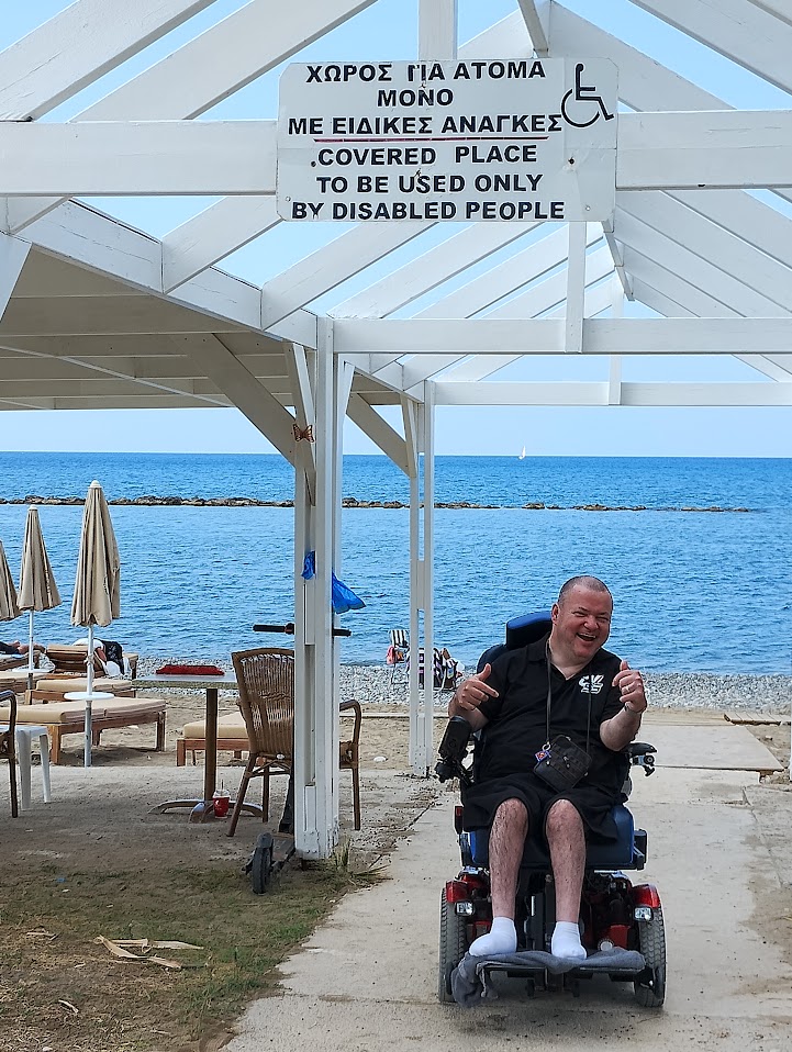 Harry poseert onder een beschutting, die volgens het opschrift voorbehouden is aan mensen met een beperking. Wie geen handicap heeft, moet elders schuilen als het regent.