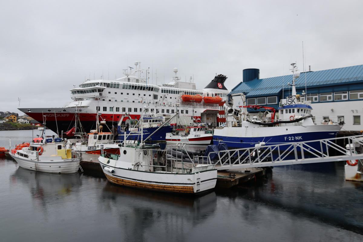 Naast het cruiseschip dat in Honningvåg aangemeerd ligt, lijken de andere schepen in het niets te verdwijnen.