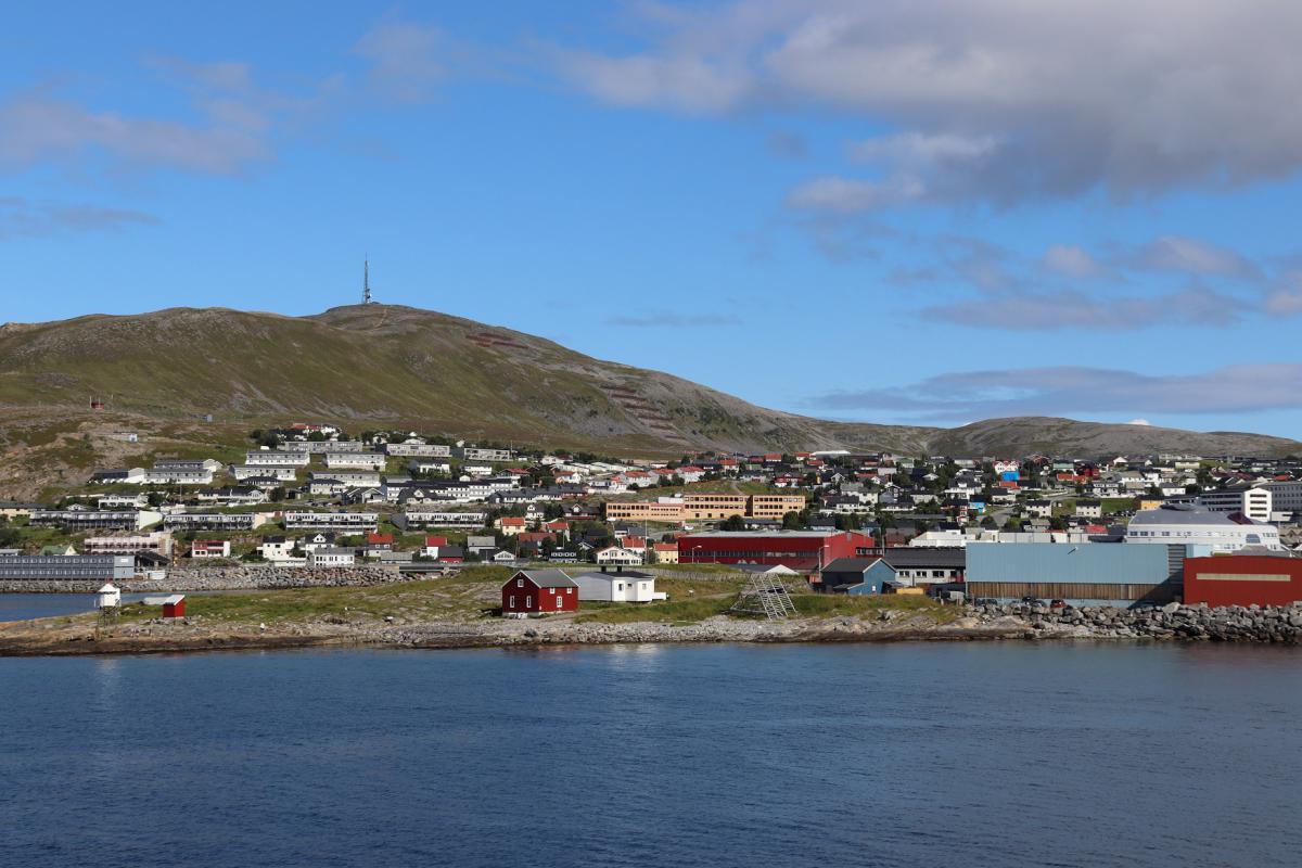 Panorama van de haven van Hammerfest, met op een bergtop een piek, wellicht de mediaanpilaar.