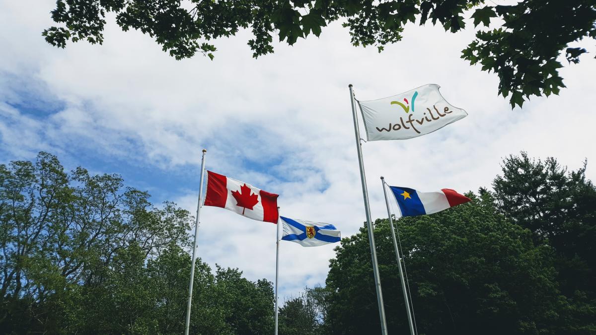 De vlaggen van Canada, Nova Scotia, Wolfville en Acadië wapperen in de lentebries.
