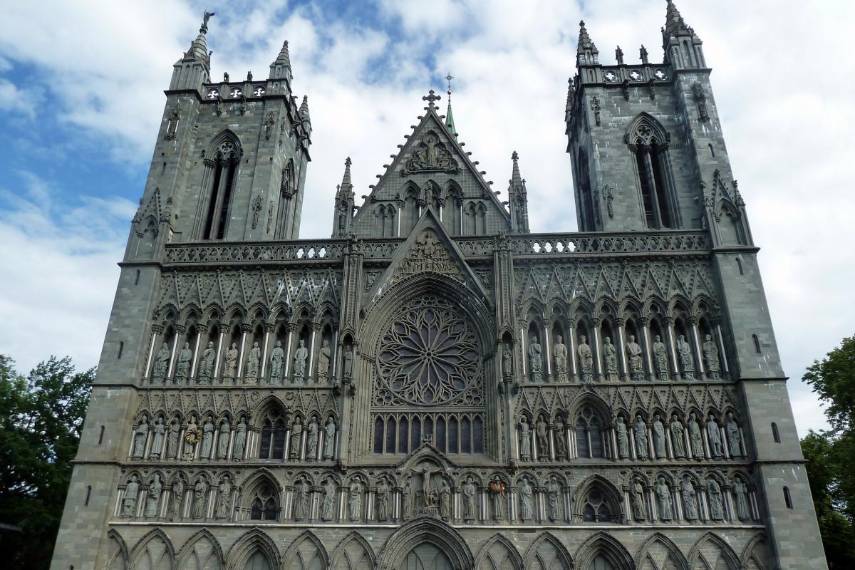 De nissen in de donkergrijze voorgevel van de gotische kathedraal zijn versierd met heiligenbeelden.