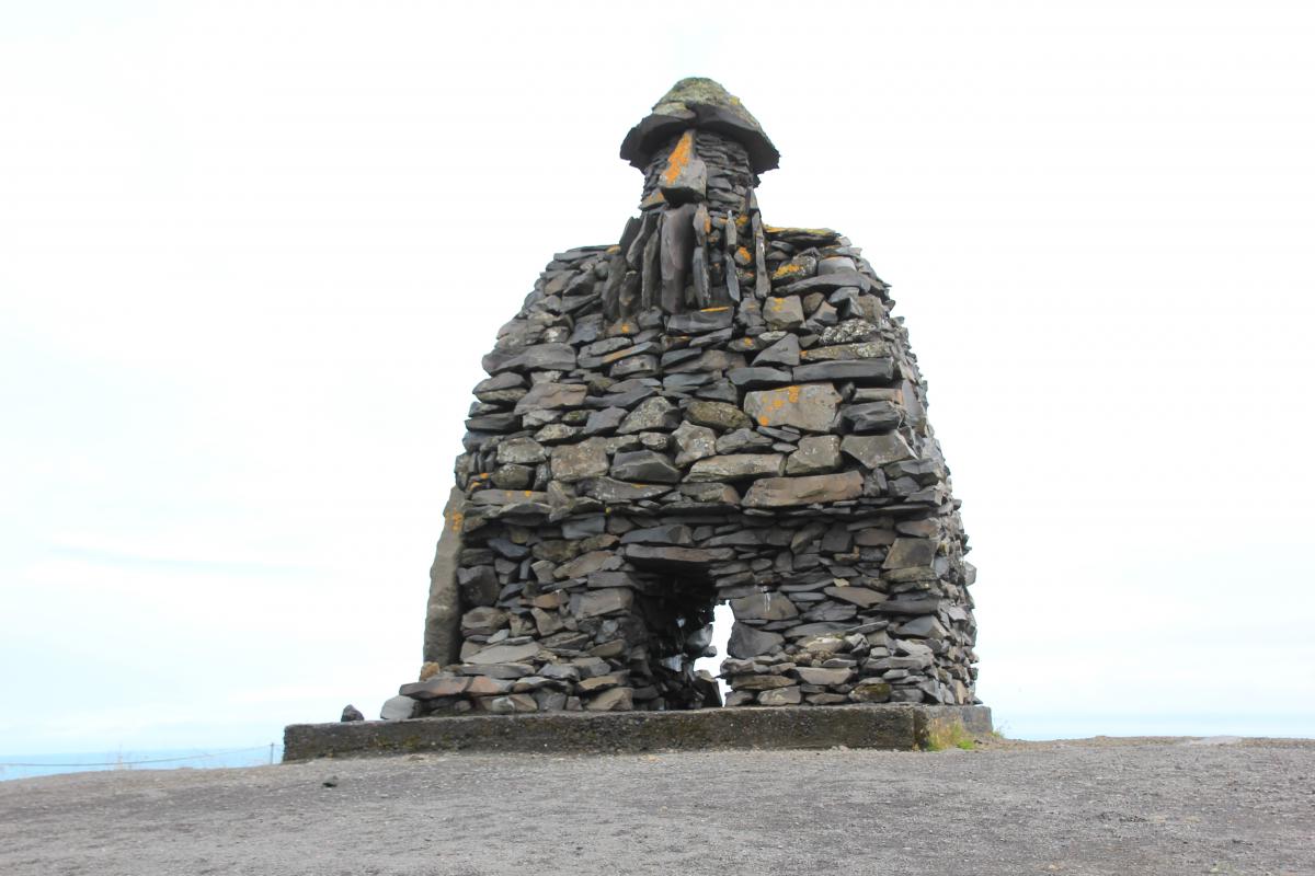 Het monument lijkt op een stenen huisje met in het midden een schoorsteen.