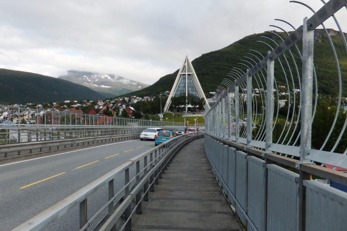 Vanaf een brug zien we de IJszeekathedraal opdoemen. Tussen de bergen zien we een grote driehoek met opvallend veel glas.