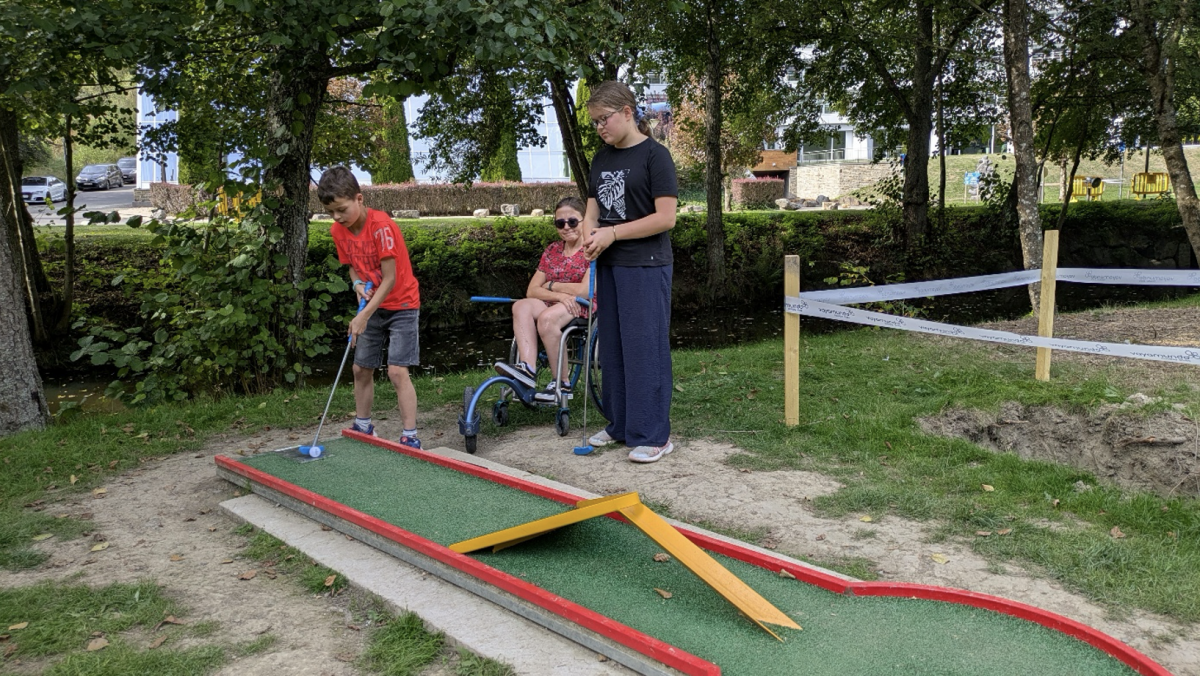 Moeder, dochter en zoon op de minigolfbaan.