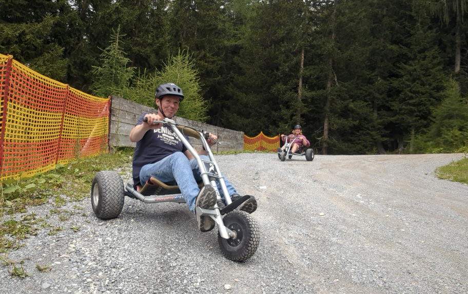 Thomas blikt jongensachtig in de lens, vanop zijn mountaincart.