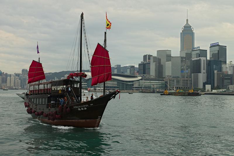 Een jonk (Chinese zeilboot) met op de achtergrond de wolkenkrabbers van Hong Kong