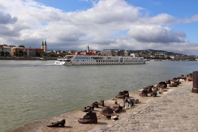 Skyline van Boedapest vanaf de oever van de Donau. Vooraan staat een rij schoenen, ter herdenking van de holocaust.