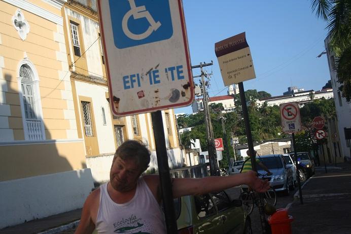 Herman tussen de verkeersborden die voorbehouden parkeerplaatsen aanduiden.