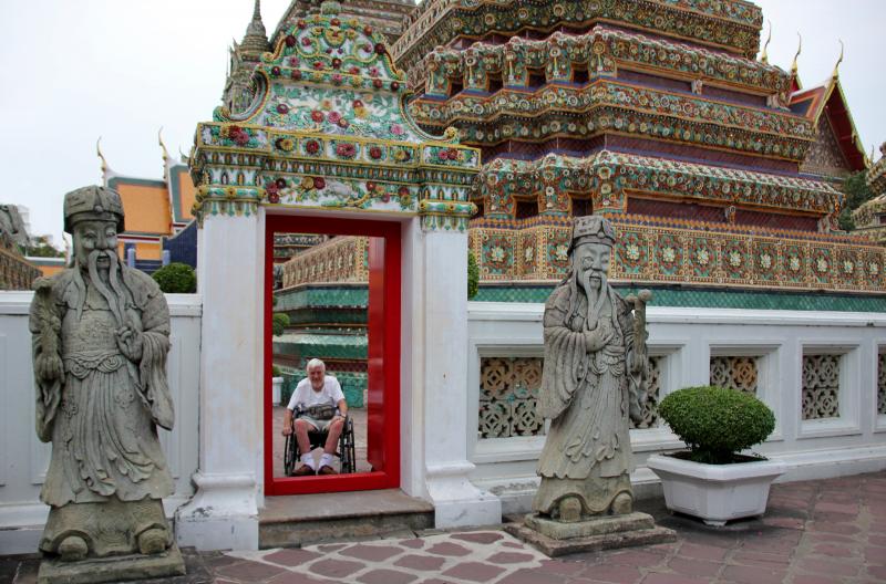 Jozef lacht ons toe door een ingang van de tempel, met een hoge drempel.