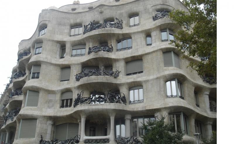 Het bekendste "huis" ontworpen door Gaudi golft zo sterk dat het uit water in plaats van steen gemaakt lijkt.