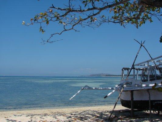 Een Balinese boot wacht op het strand om weer uit te varen.