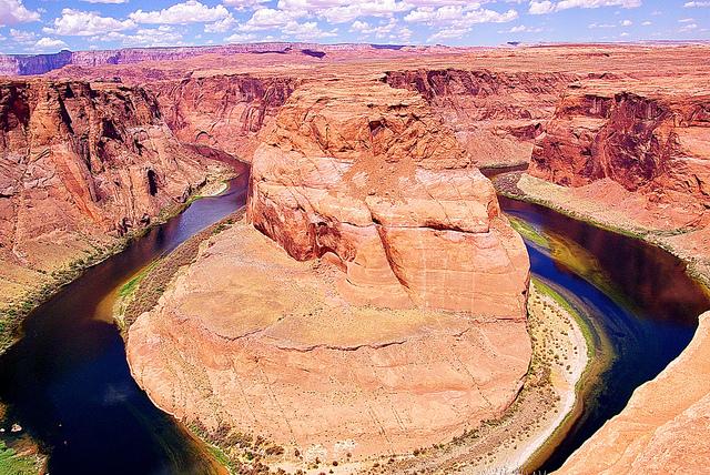 De roodbruine canyon wordt doorsneden door een rivier, die een hoefijzerachtige bedding ingesneden heeft.