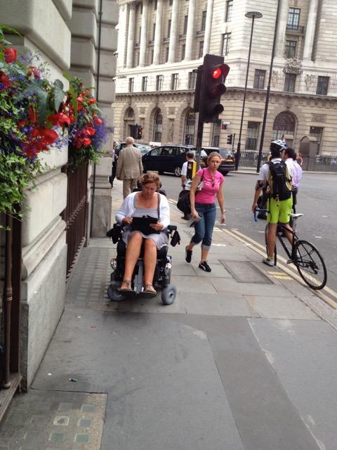 Anne rijdt met de elektrische rolstoel op het voetpad in hartje Londen.
