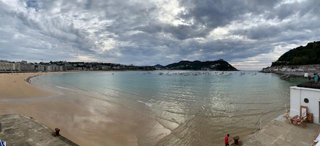 Omboord door zandstrand en bergen heeft deze baai de vorm van een venusschelp