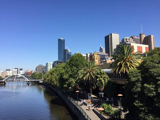 Futuristische wolkenkrabbers en palmbomen op de oever van de Yarra-rivier.