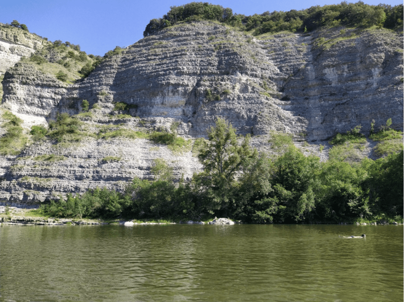 Zwemmen in de Ardèche en zonnen op de rivieroever, tussen huizenhoge rotsen.