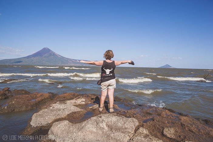 Deelnemer, met Project U/Turn t-shirt probeert het landschap van bergen en zee te omarmen.