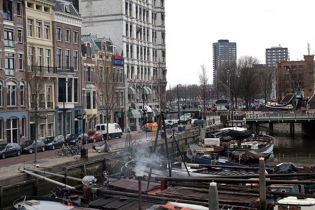 Kleine vrachtschepen liggen aangemeerd aan de kade.