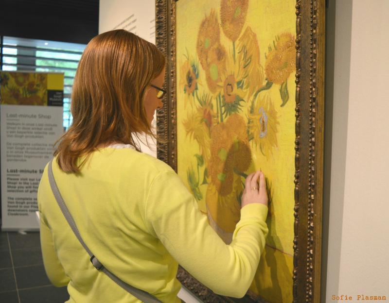 Karmen betast een kopie van het schilderij De Zonnebloemen. (foto Sofie Plasman)