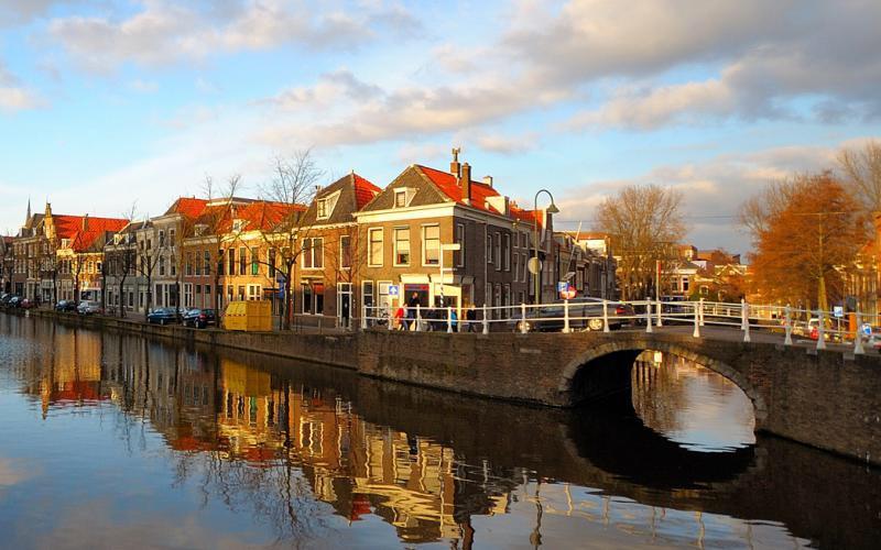 Een winterse foto van Delft. Het pittoreske stadje wordt weerspiegeld in het water van de Schie.