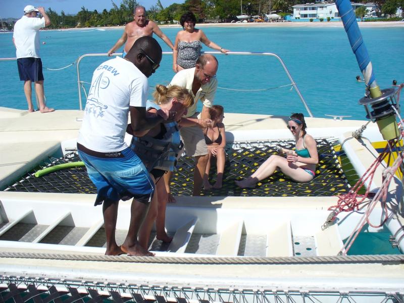 Nadine wordt van op de catamaran in het water geholpen.